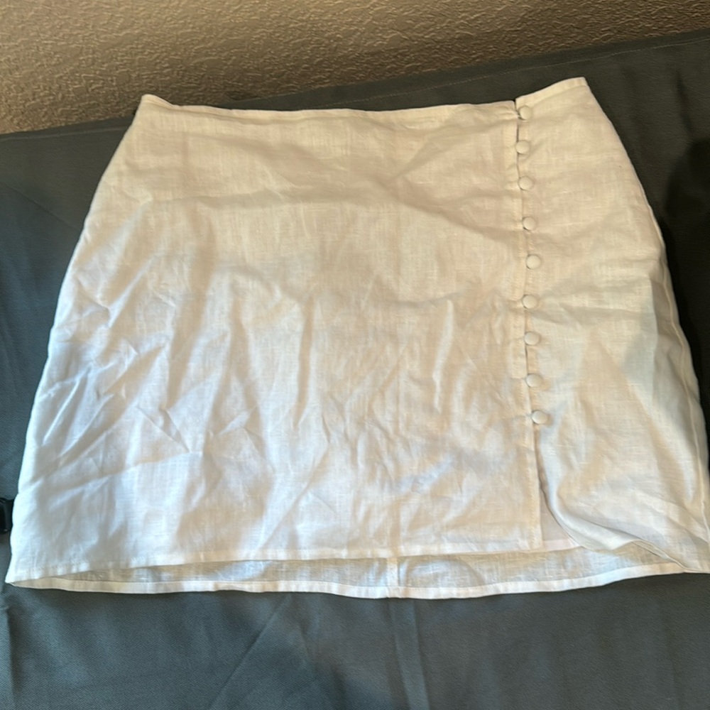 Medium white short skirt with open button side